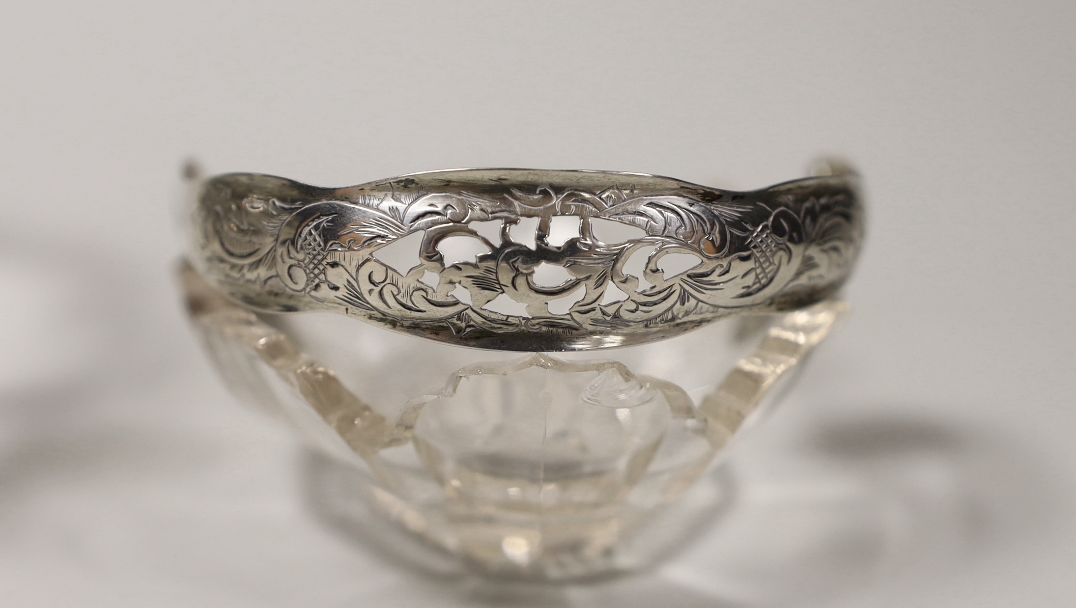 A late 19th century Dutch white metal mounted cut glass sweetmeat basket, length 21.4cm and a similar smaller basket.